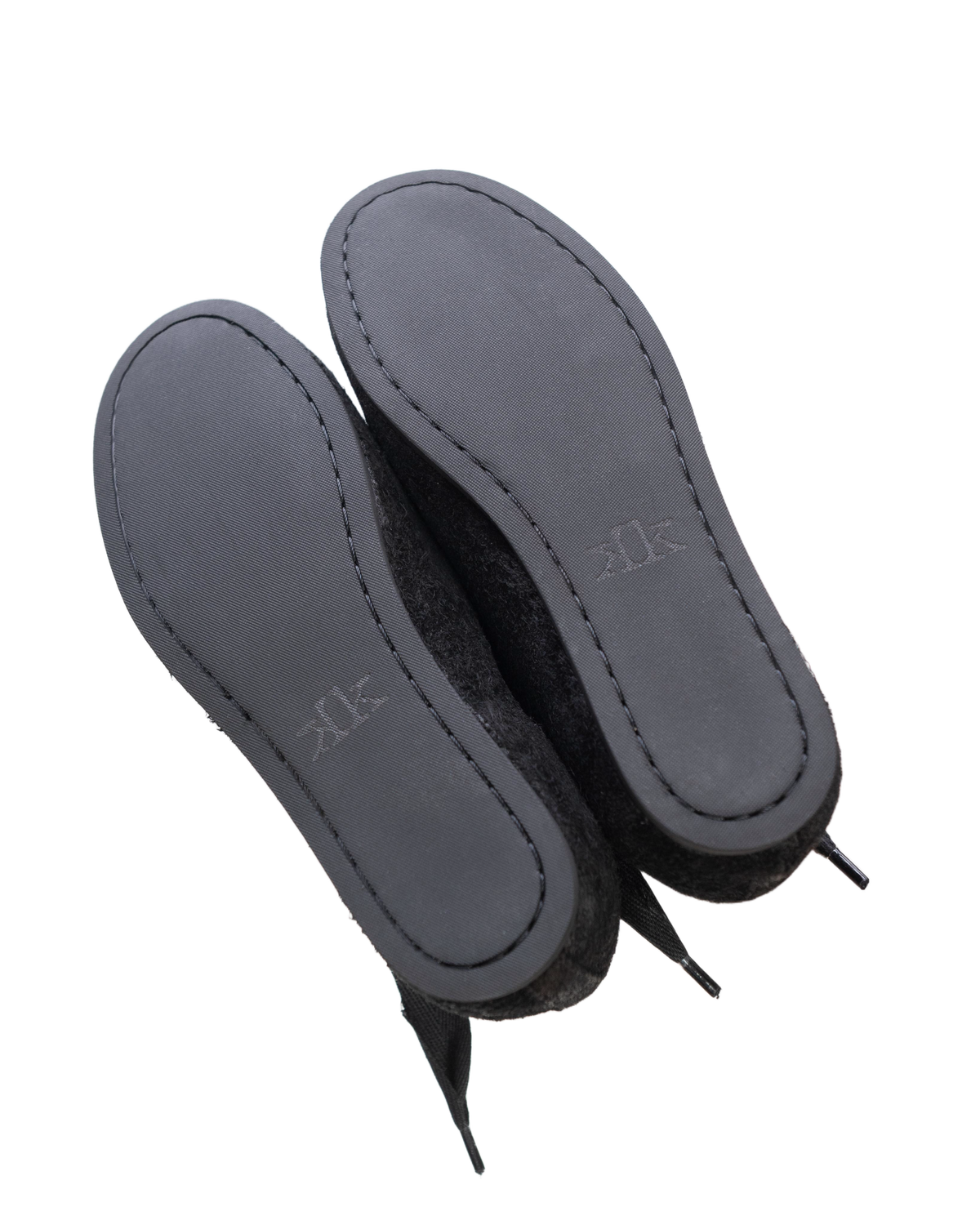 Pair of black K-Two Studios Sash Flats shown from below with smooth sole and minimalist design.